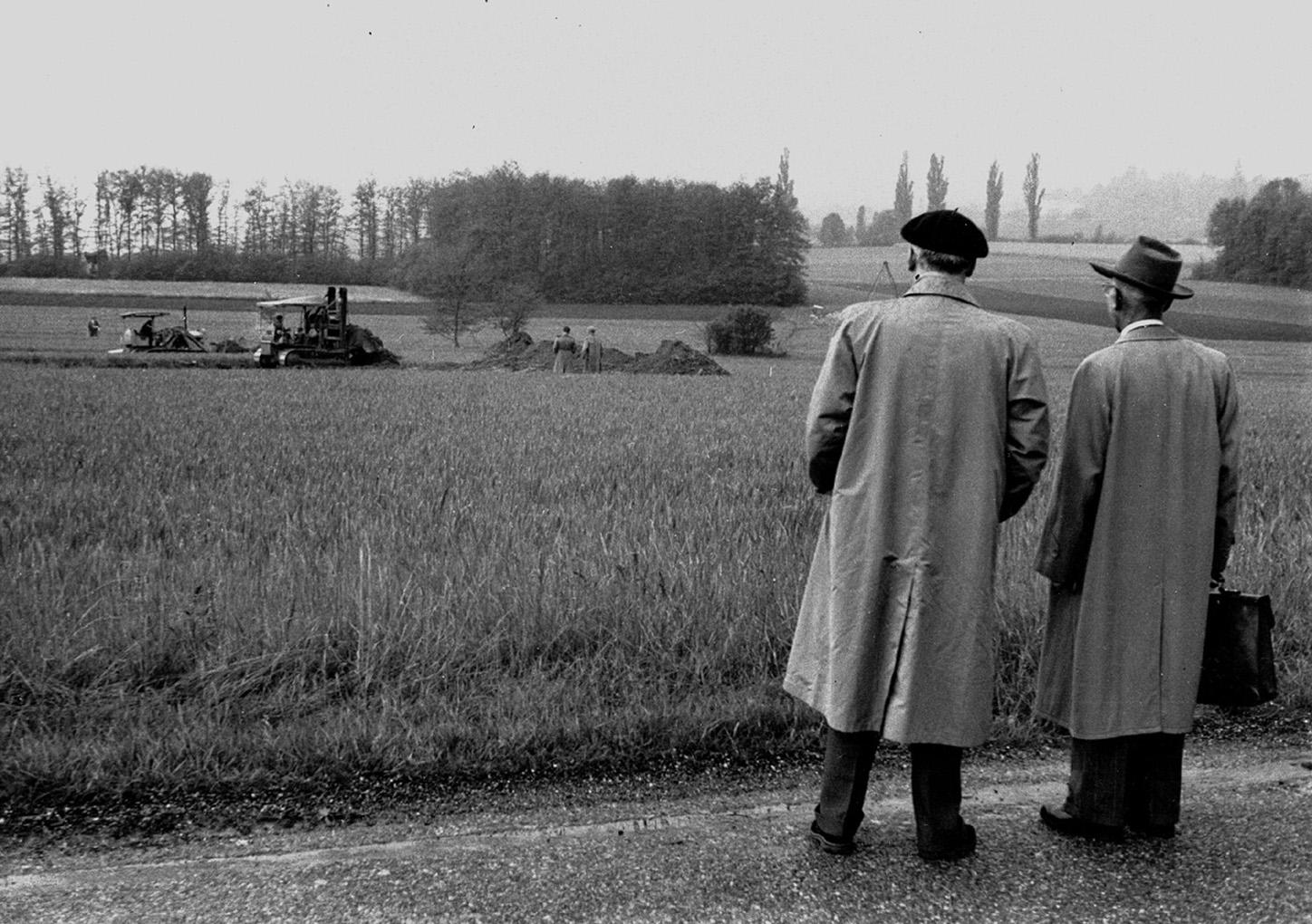 Deux hommes regardant un champ où commence un chantier